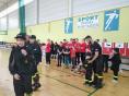 Kilkanaście dzieci w strojach sportowych i strażackich stoi na sali gimnastycznej.